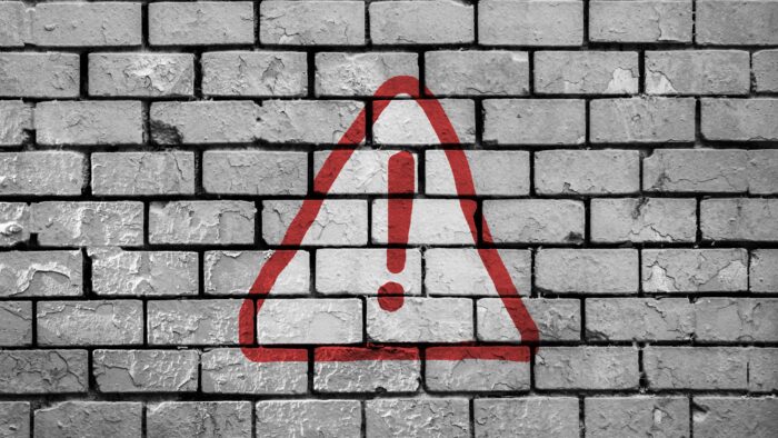 caution sign on brick wall