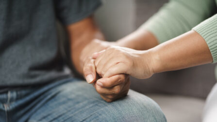 One person holding hands of another person in support