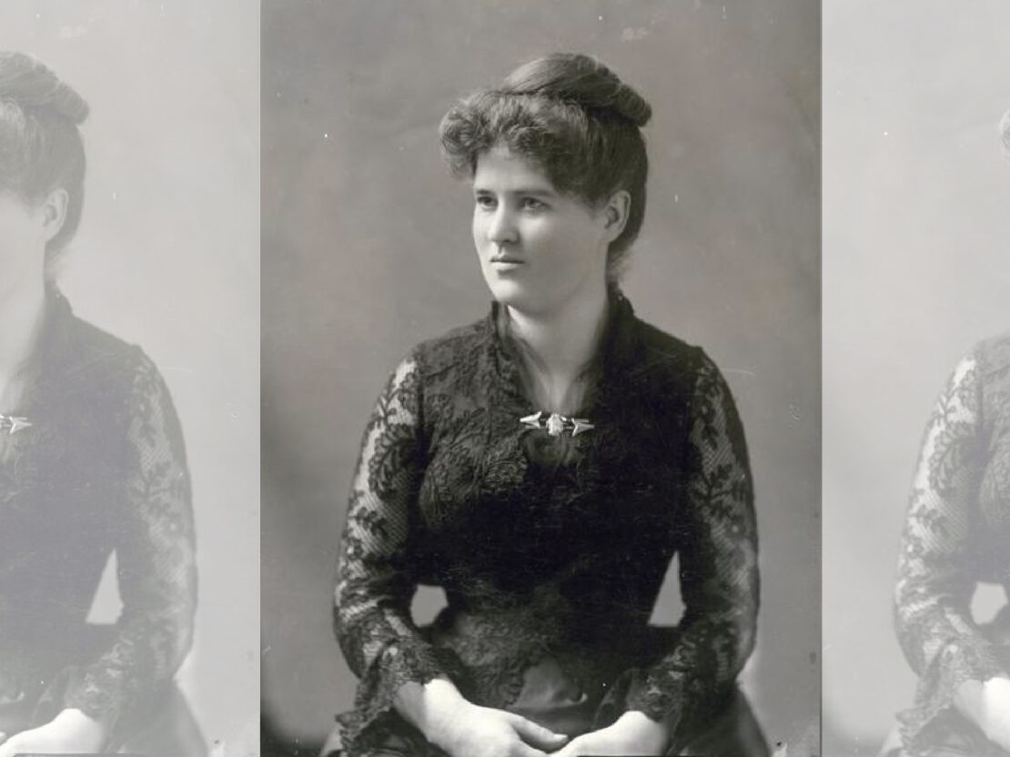 A black and white portrait of Belle wearing a formal dress, seated, with her hands in her lap, looking to the left of the viewer.