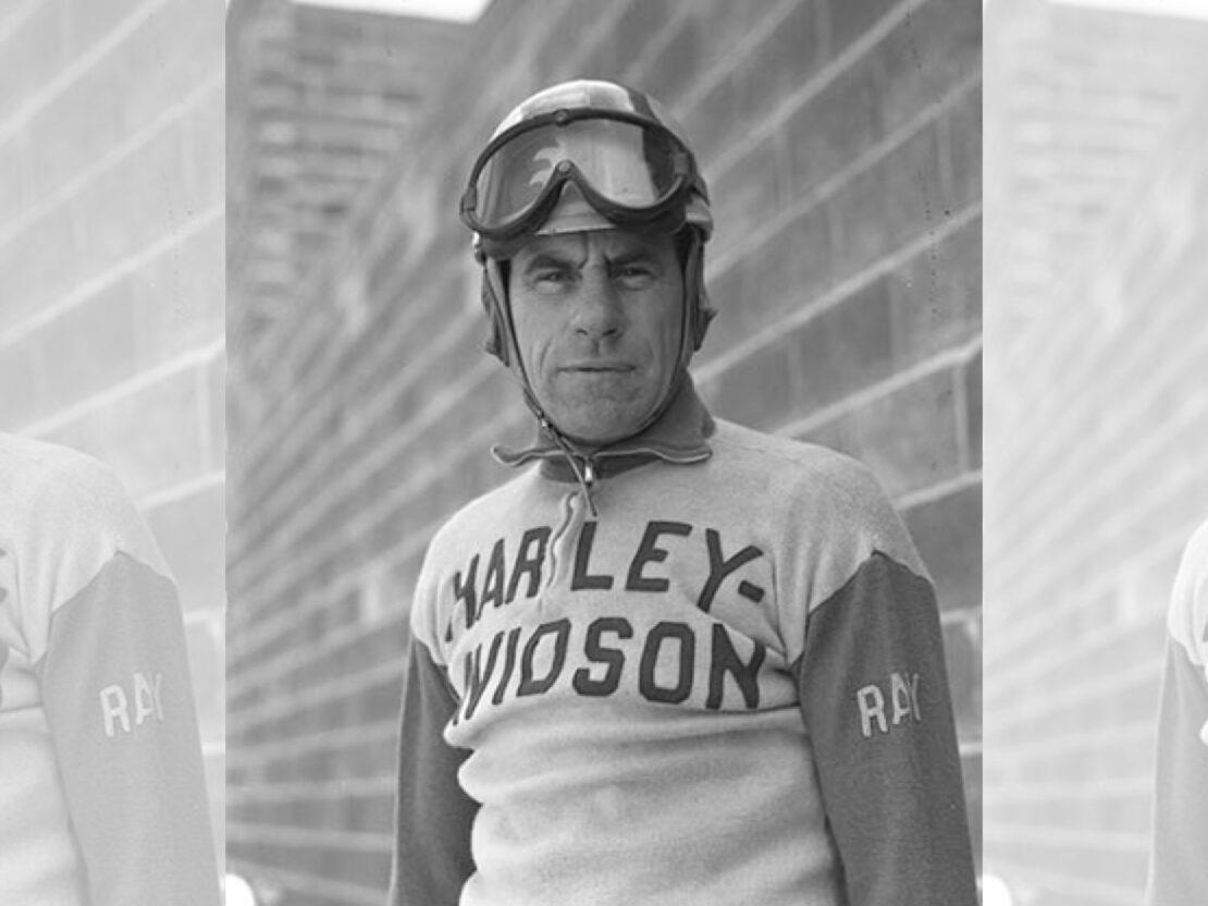 A black and white image of a man wearing a sweater with the word "Harley" visible on it, and goggles. His head and shoulders are visible and he is looking directly at the viewer.