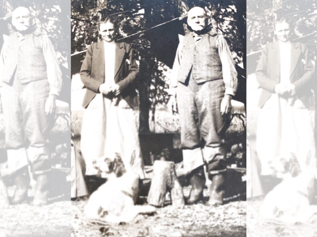 A black and white photo of Carrie standing next to her father in front of trees.