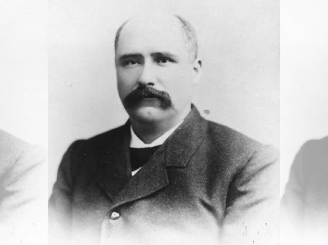 This black and white photo of an older Charles Clark shows his head and shoulders. He looks to the left of the viewer and his mouth is closed.
