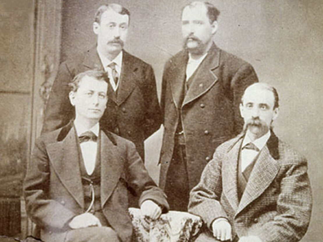 A black and white photo of John Kimberly, Frank Shattuck, Charles Clark, and Havilah Babcock.