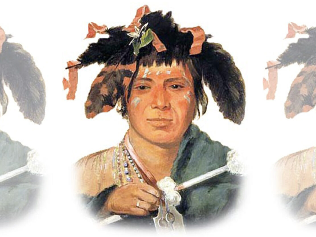 A color image showing a young person with a feather headdress and painted marks on their face.