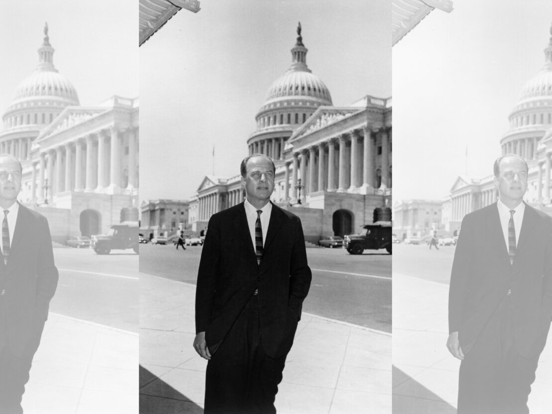 A black and white image of Gaylord Nelson standing outside with the United States Capitol building behind him.