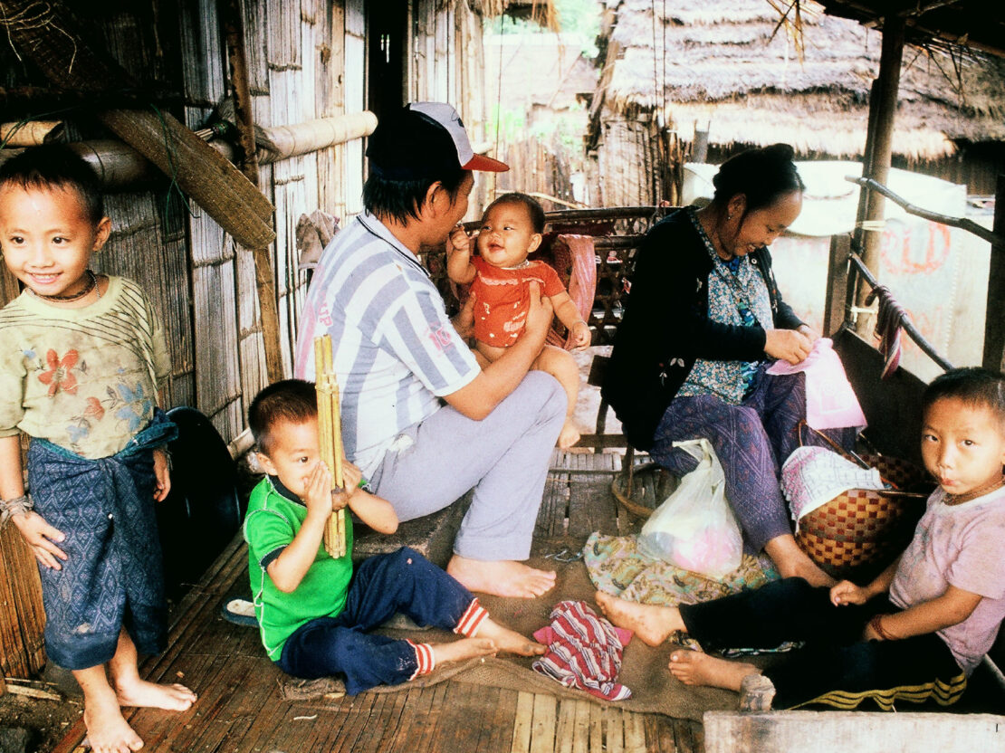 A color image of two adults and four children inside a small structure.
