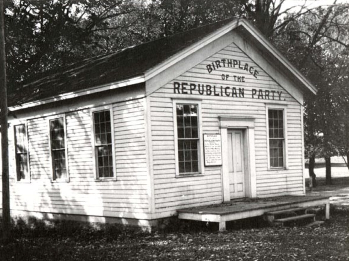 A black and white photograph showing a small white house with the words, "Birthplace of the Republican Party" painted above the door.
