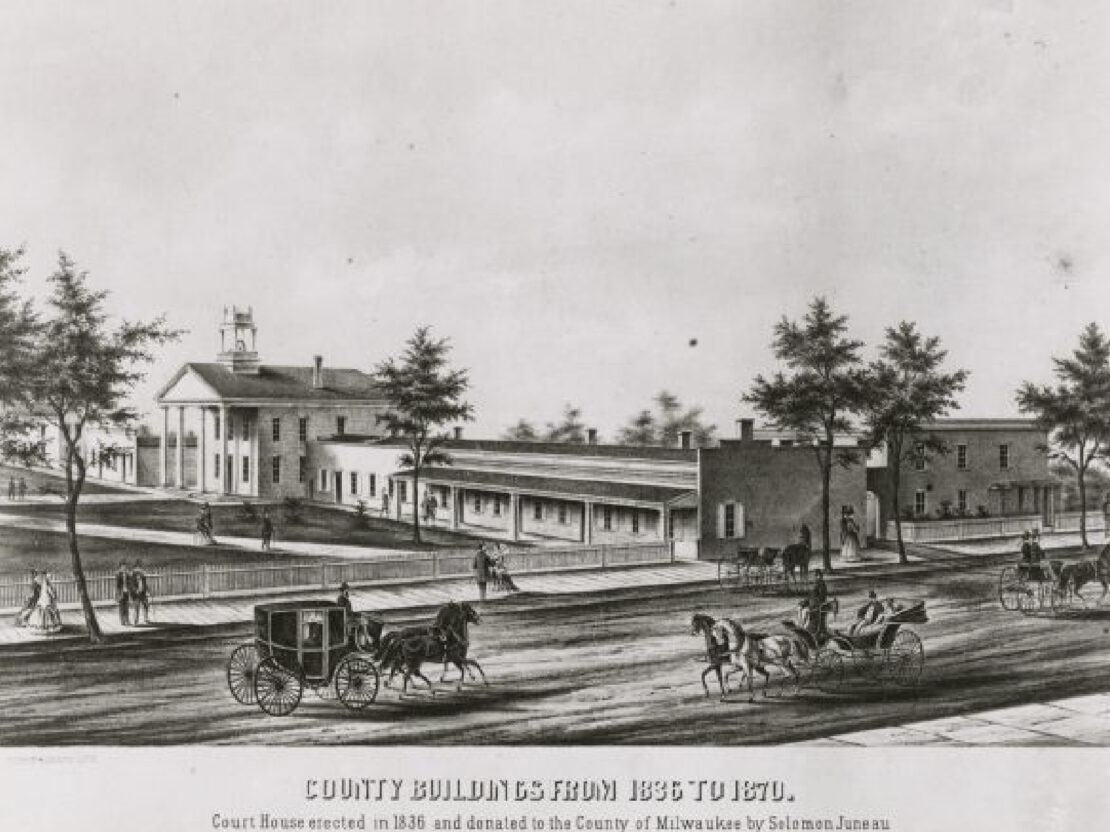 A black and white drawing of a large building with columns, next to a road where horses are pulling carriages.