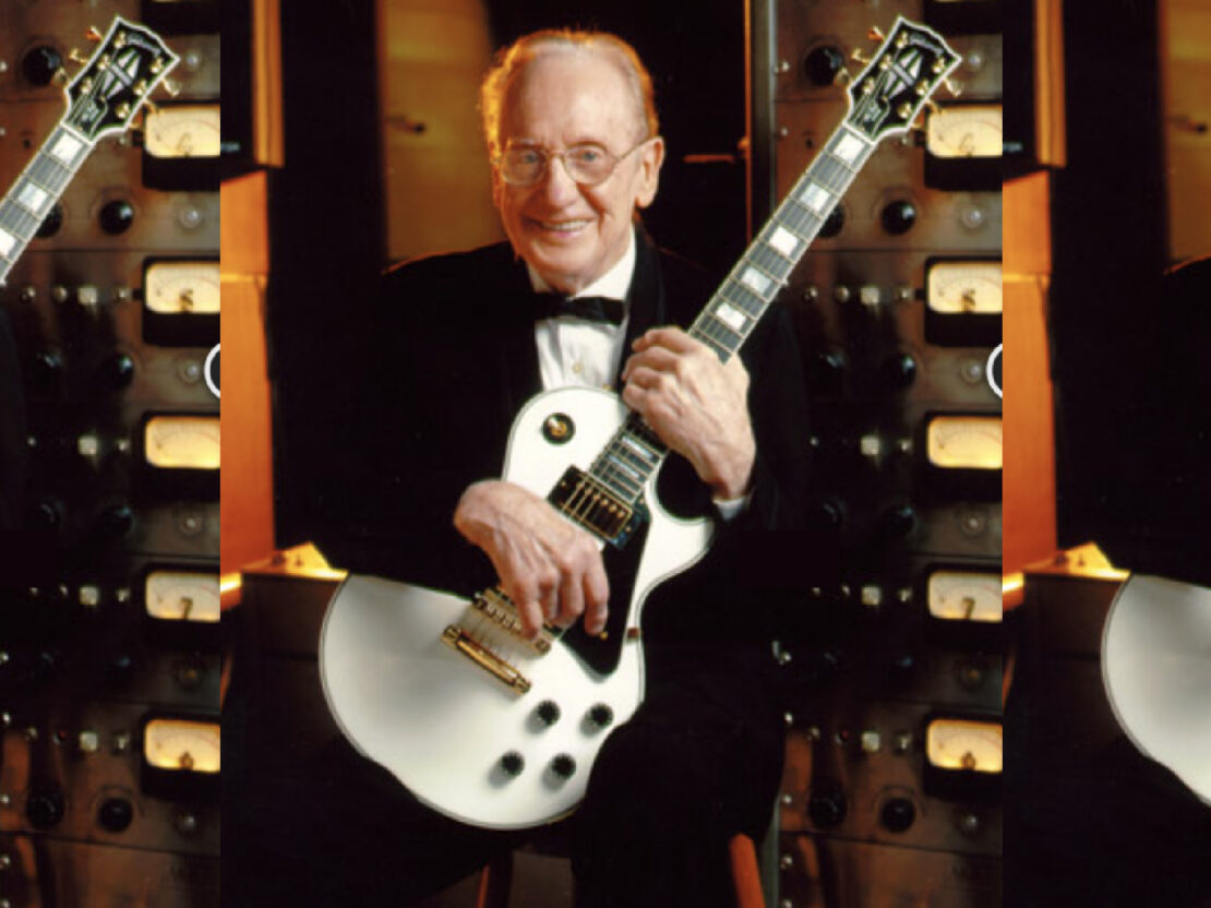 A color image of Les Paul seated, in a tuxedo, holding an electric guitar, next to a multitrack recorder.