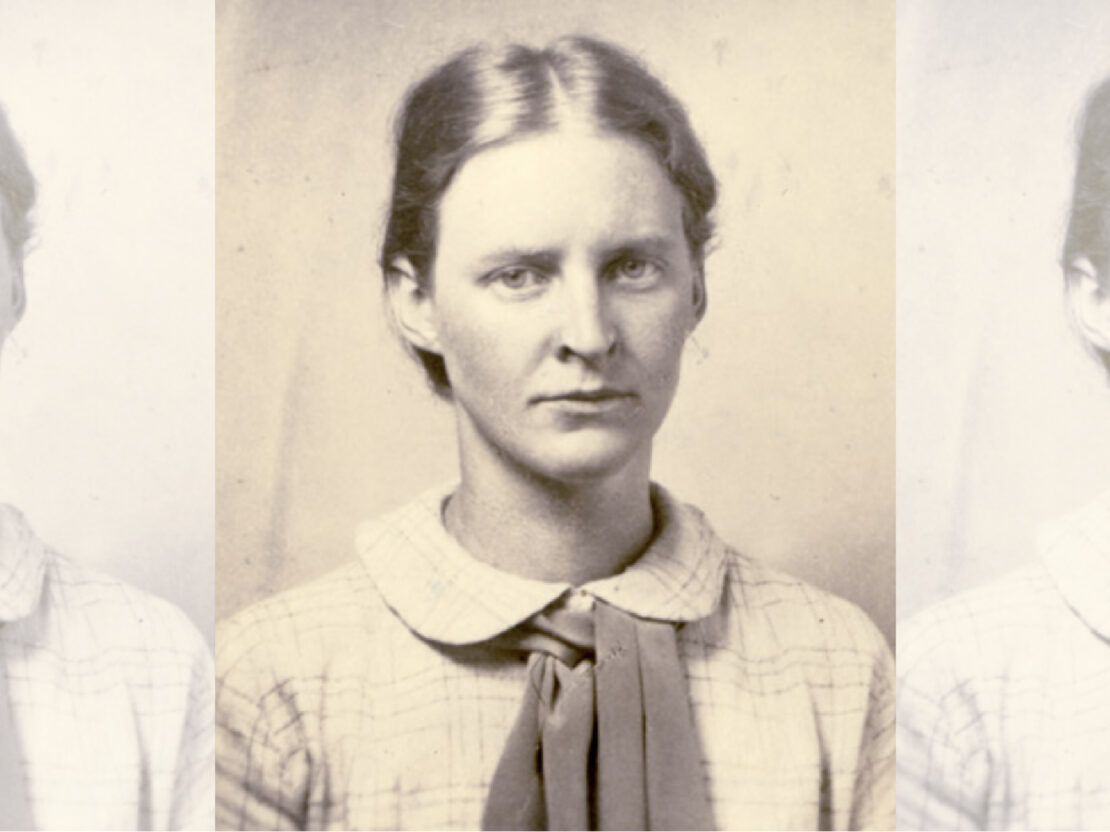 A black and white photograph of Mildred. In the photo her head and shoulders are visible. She looks directly at the viewer and has a serious expression on her face.