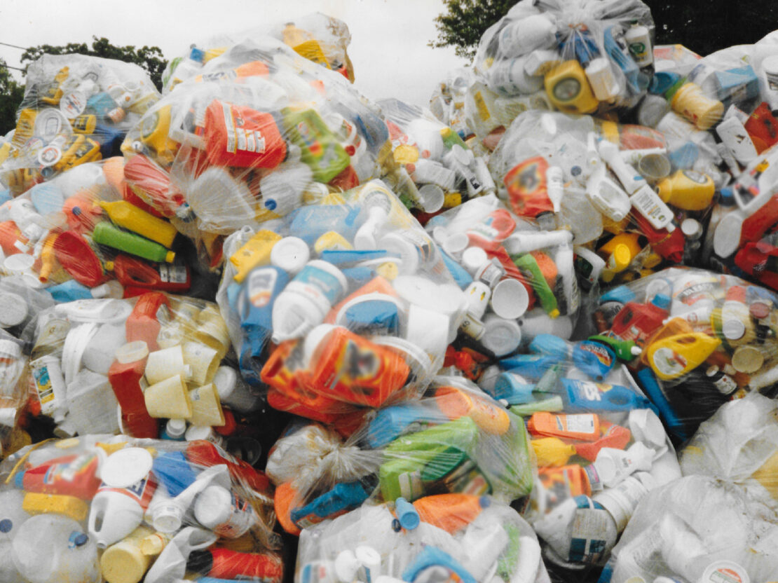 A color photograph showing a mound of clear plastic bags, each full of many different colors of plastic items.