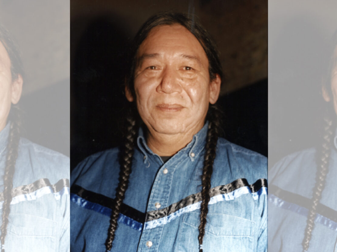 Color photograph portrait of Walter Bresette. In the photo, his head and shoulders are visible. He is looking at the viewer with a slight smile on his face.